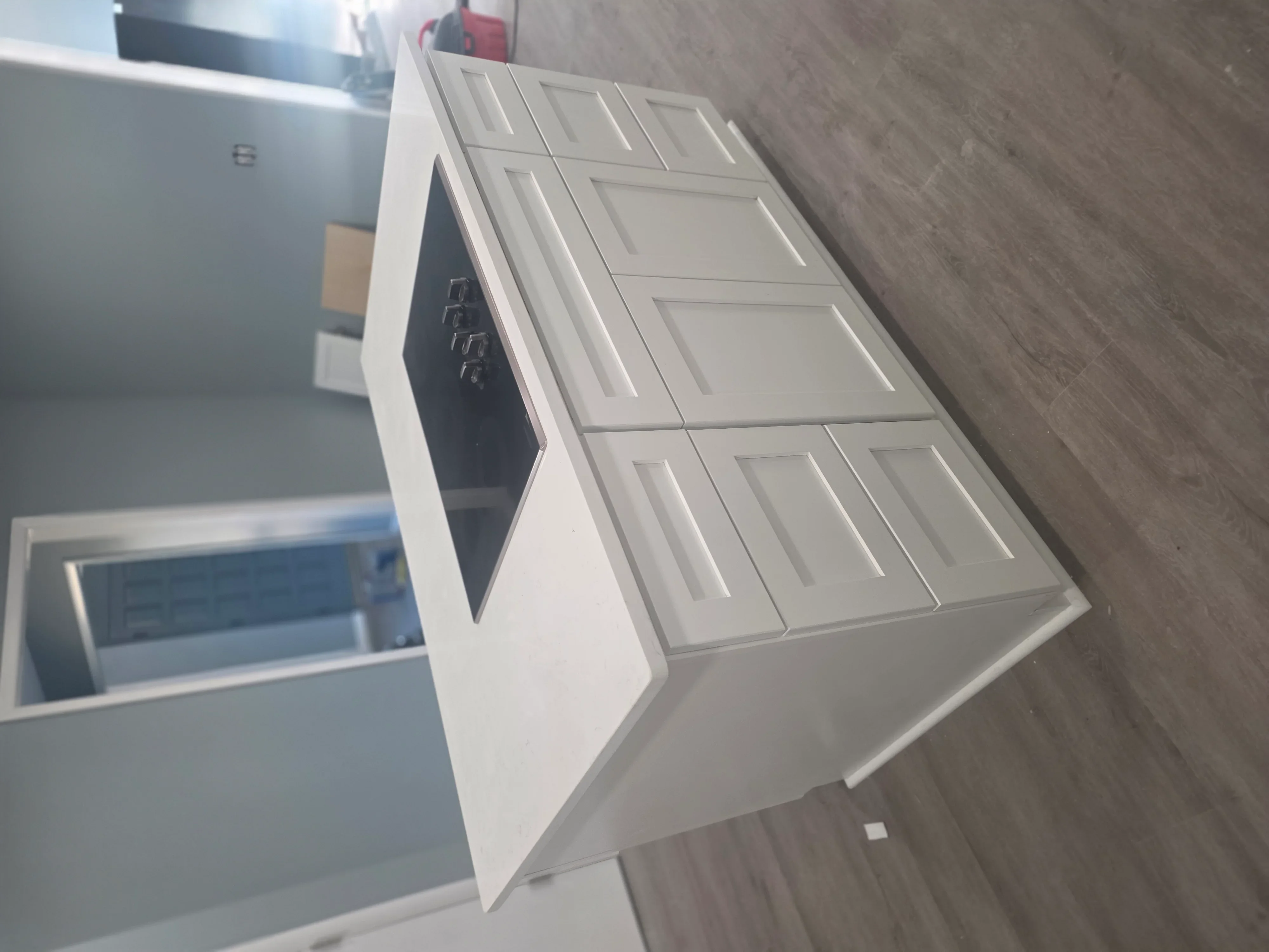 White bathroom vanity with dual sinks and raised panel cabinet doors installed in bathroom