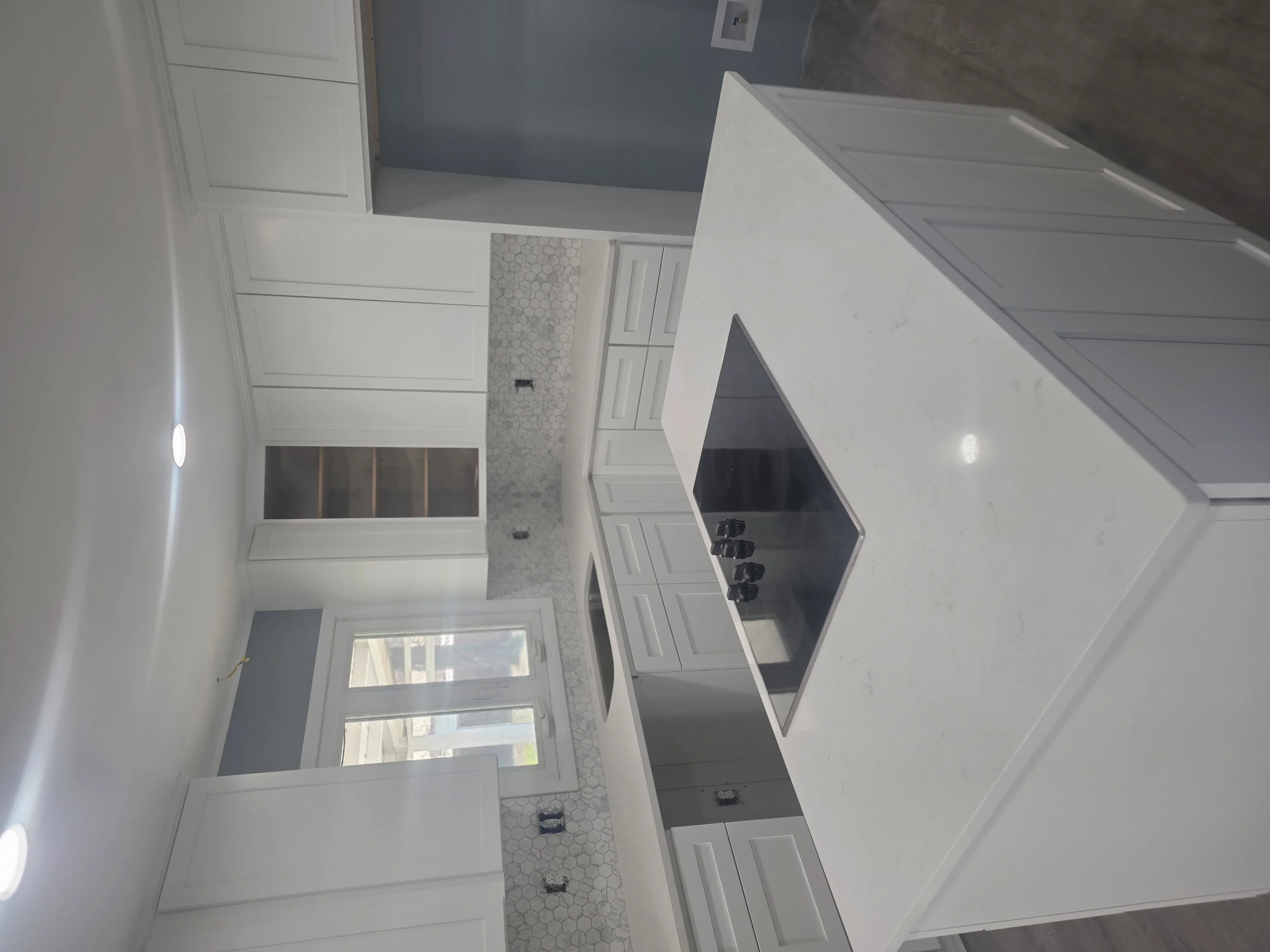Modern bathroom with white cabinetry, hexagonal tile accent wall, and recessed lighting