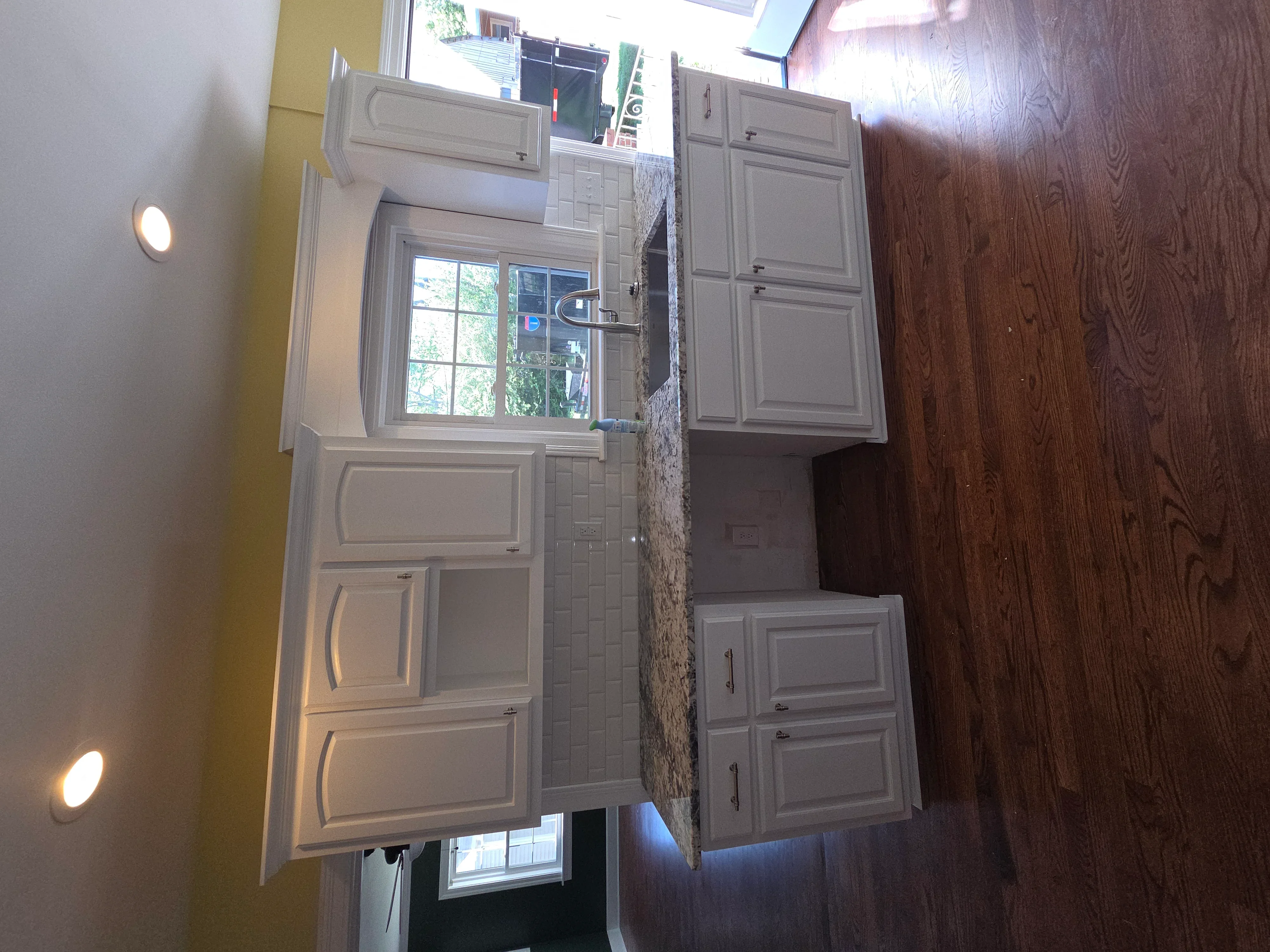 Kitchen with gray painted cabinets, granite countertops, and recessed lighting