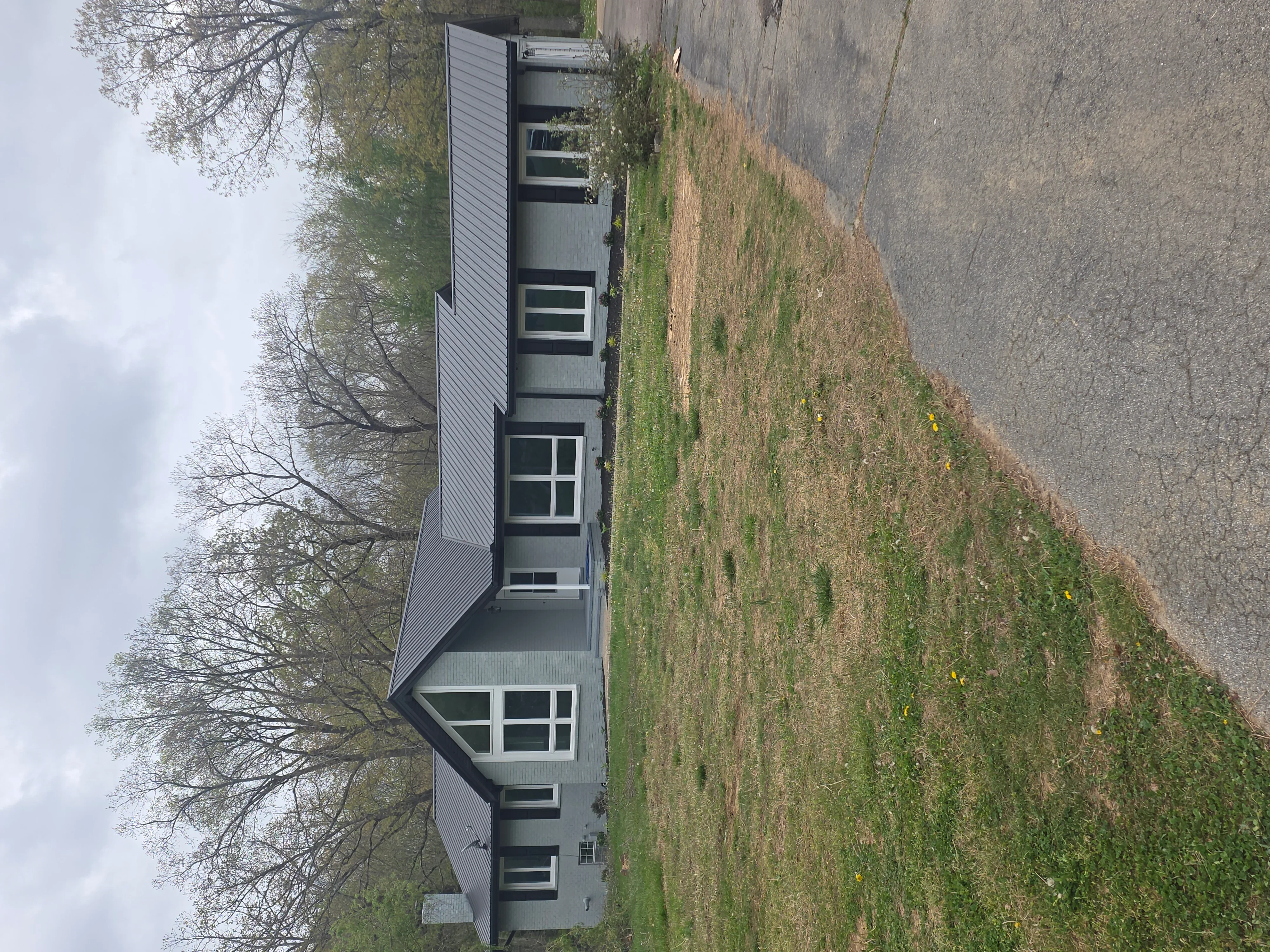 Modern gray and white sided home with new windows and manicured lawn