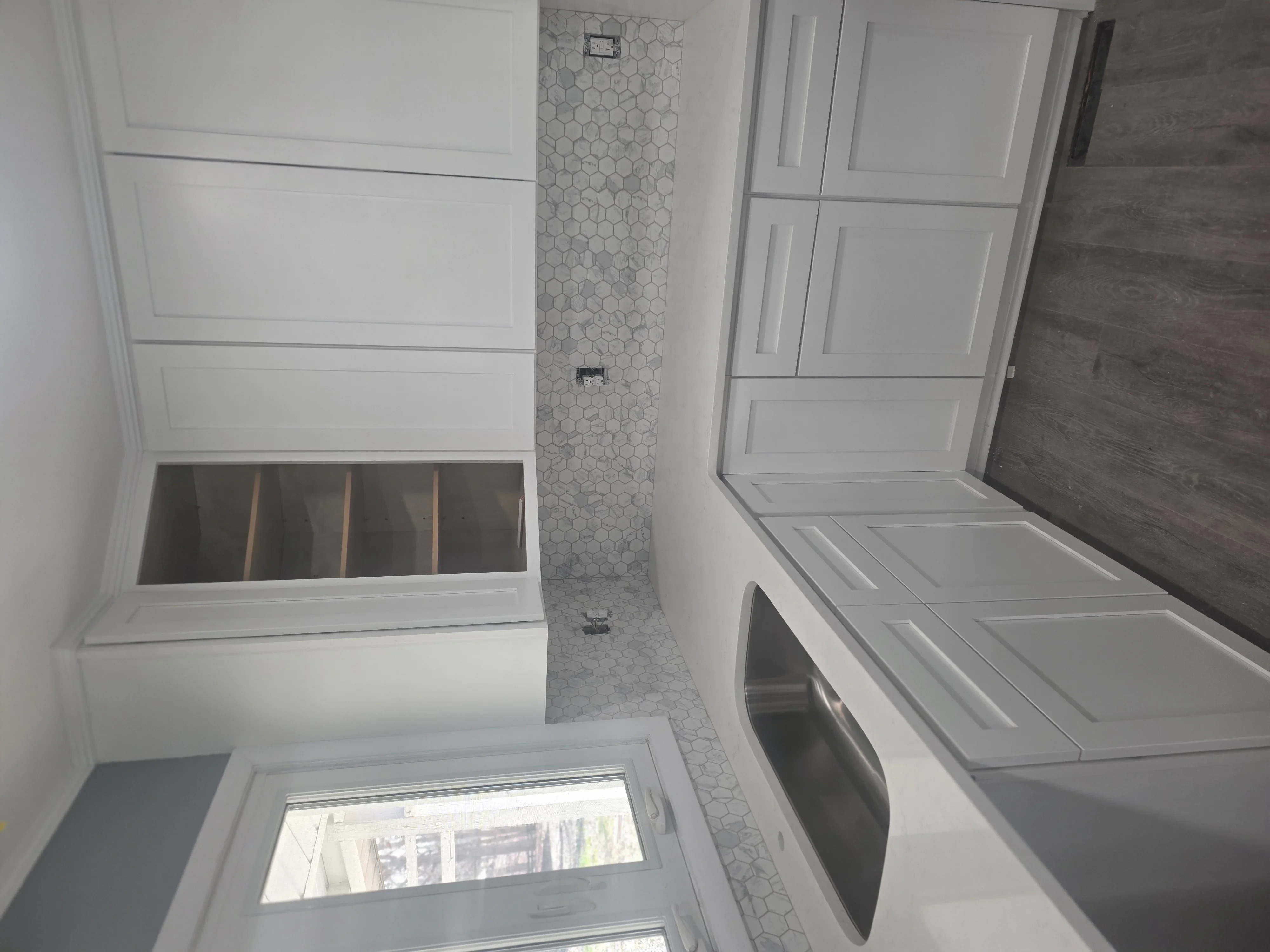 Modern bathroom with white cabinetry, hexagonal tile accent wall, and new soaking tub