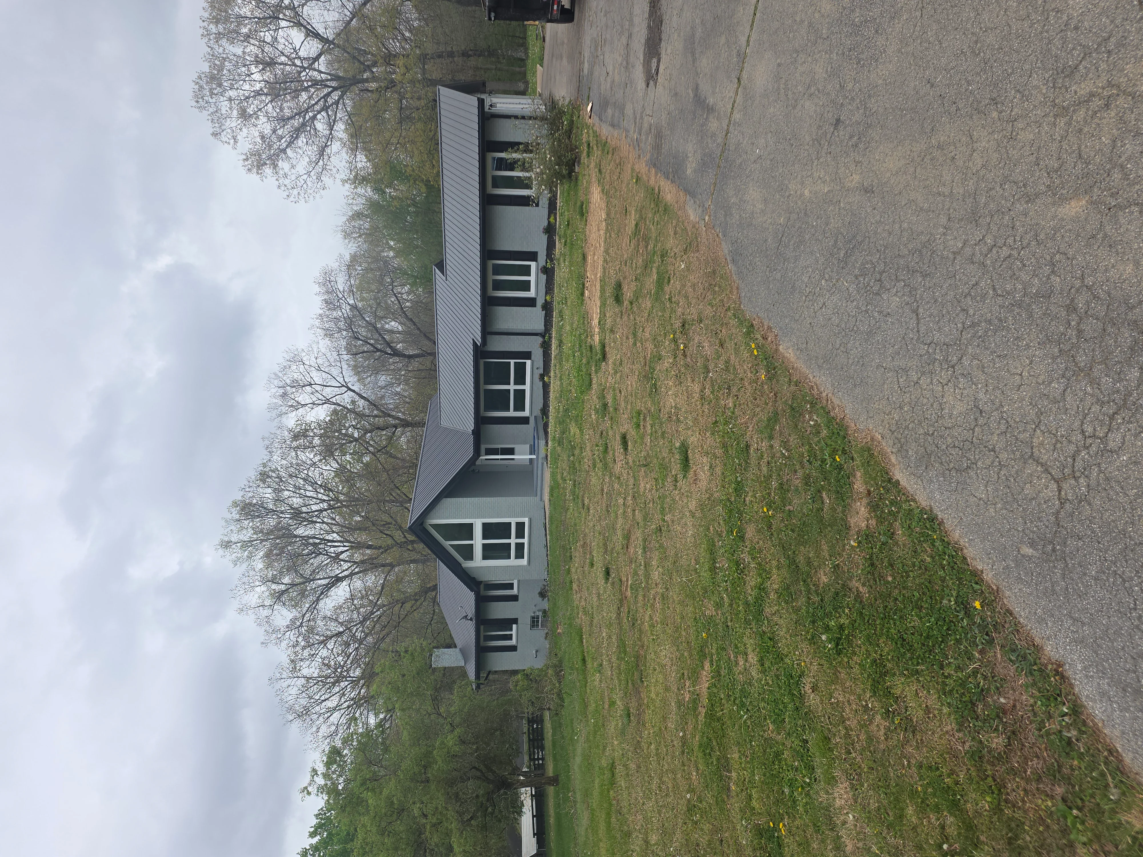 Modern home with new gray vinyl siding, white trim, and updated windows